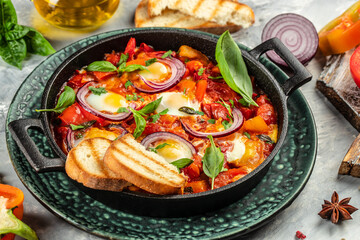 Shakshuka. Fried eggs with vegetables in a cast iron pan, traditional middle eastern traditional...