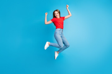 Fototapeta na wymiar Full length photo of cheerful glad girl dressed trendy clothes fly air with raise hands isolated on blue color background