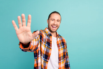 Photo of handsome cheerful man with stubble long hairstyle dressed checkered shirt give you...