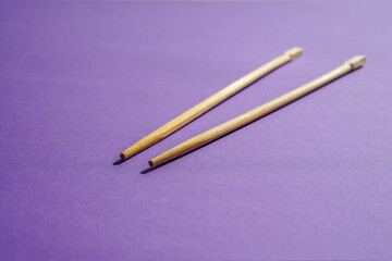 Wooden chopsticks on a purple background