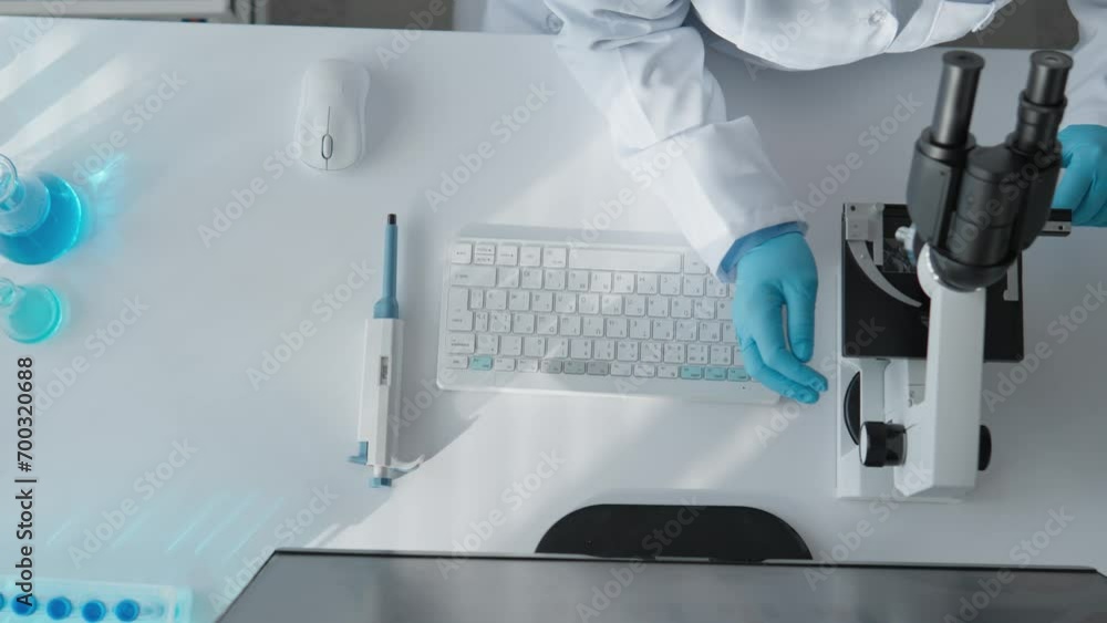 Aufkleber View from above. A true research scientist in a laboratory that is the center of innovation in medicine. Under the microscope, it studies the properties of cells, and computer analysis takes research
