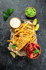 Fish and chips traditional British meal served with mashed peas, vegetable salad, tartar sauce, banner, menu, recipe place for text, top view