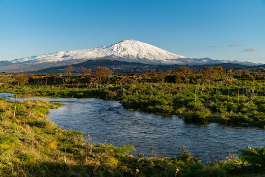A seasonal river flows under the massive snowcovered Etna volcano. Favare Santa Venera 