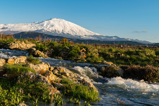 A seasonal river flows under the massive snowcovered Etna volcano. Favare Santa Venera 