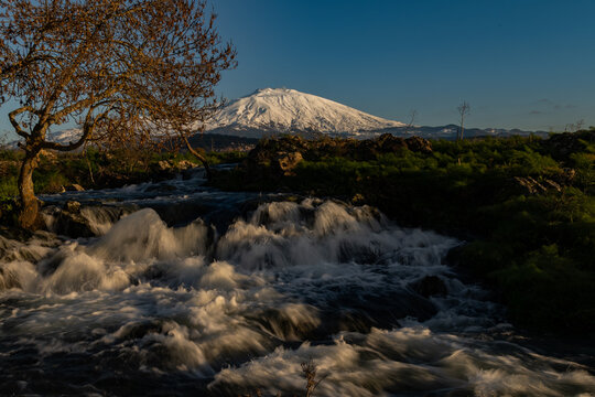 A seasonal river flows under the massive snowcovered Etna volcano. Favare Santa Venera 