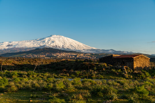 A seasonal river flows under the massive snowcovered Etna volcano. Favare Santa Venera 