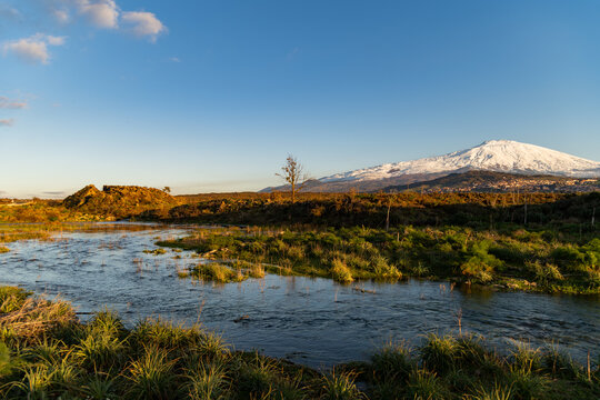 A seasonal river flows under the massive snowcovered Etna volcano. Favare Santa Venera 