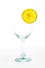 Glass with a transparent cocktail and lemon