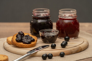 Blueberry jam on wooden plate with knife and bread. Made in Sicily