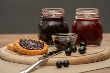 Blueberry jam on wooden plate with knife and bread. Made in Sicily