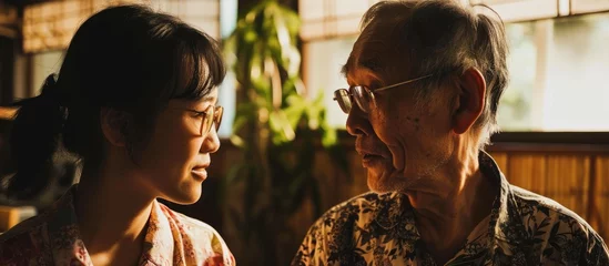 Foto op Plexiglas Asian daughter and elderly father enjoying quality time and conversation at home. © TheWaterMeloonProjec