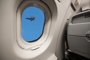 A stealth fighter airplane was spotted looking out the window of a commercial flight