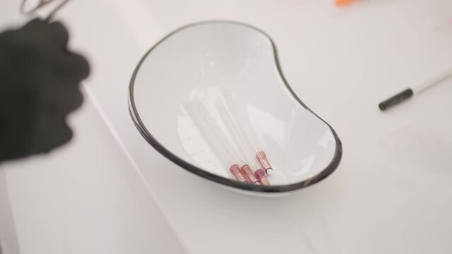 Threads for lifting the face. The doctor puts preparations for lifting the face with threads into a sterile container