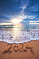 Happy New Year 2024 concept, lettering on the beach. Written text on the sea beach at sunrise. - 700341868