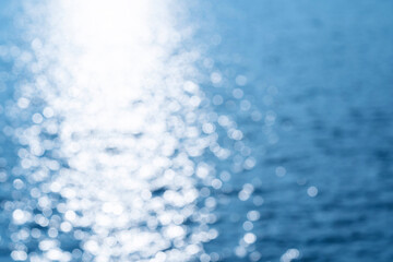 Abstract bokeh background from summer blue sea water at the beach - panoramic banner. Water bokeh backdrop