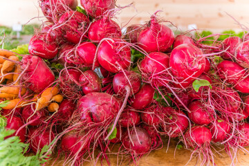 Close up of radishes on display at an outdoor farmers' market.