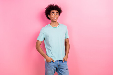 Photo of funky cheerful guy wear blue t-shirt looking walking smiling empty space isolated pink...