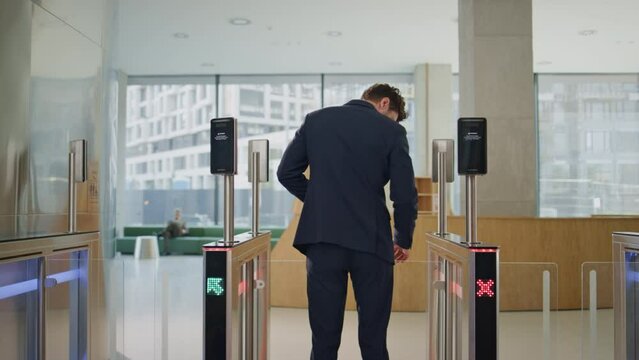 Man leaving office turnstile trying unlocking security system by smartwatch. 