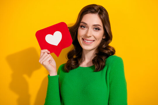 Photo of lovely adorable cute woman showing social media instagram facebook like isolated on yellow color background