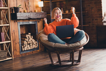 Full length portrait of funny delighted person sit chair use netbook raise fists attainment...