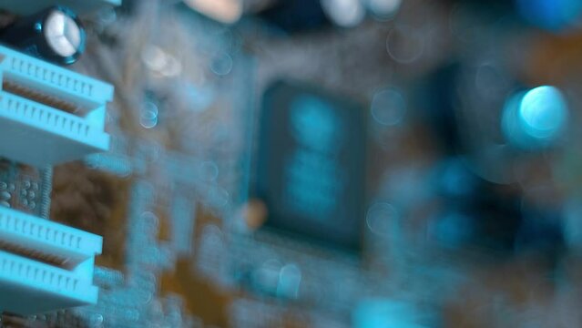 On the printed circuit board of a computer motherboard are microchips that ensure optimal operation of the main processor. Closeup. Macro. Shallow depth of field. Shot in motion