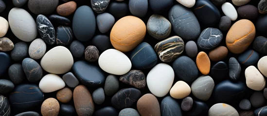 Cercles muraux Pierres dans le sable background of white and black stones lying on the beach sand