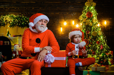 Winter holiday. Christmas decoration. Santa Claus with little helper near Christmas tree. Santa man...