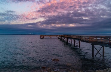 Cloudy Sunset Over A Pier On The Ocean