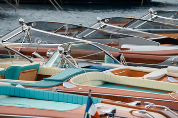 Fototapeta na wymiar Few luxury retro motor boats in row at the famous motorboat exhibition in the principality of Monaco, Monte Carlo, the most expensive boats for the richest people, boats for rich clients