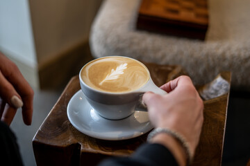 Latte With Pretty Foam Art in Tea Cup Person Holding