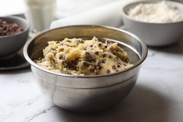 Chocolate chip cookie dough in bowl on table, closeup