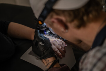 Tattoo Artist Close Up Action of Tattooing Client Hand