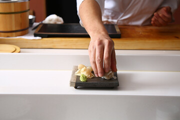 The hand of a Japanese chef holding sushi 초밥을 쥐고 있는 일식 쉐프의 손