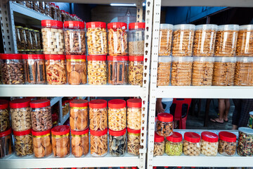 Variety of Chinese New Year cookies in jars place on shelf of retail for sale - obrazy, fototapety, plakaty