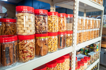 Variety of Chinese New Year cookies in jars place on shelf of retail for sale