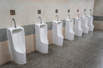 Empty row of outdoor urinals men public toilet. White ceramic urinals for man in toilet room....