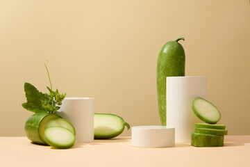 A set of podium in cylinder shaped decorated with slices of winter melon. Beige background. Winter melon (Benincasa hispida) helps in controlling bleeding