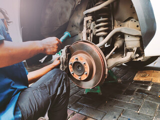 A mechanic change brake pads and system check in basic maintenance. Hands a technician man...