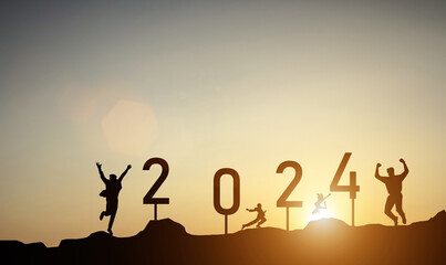 Silhouette of a jumping person with the numbers 2024 on the mountain at sunset against the background of morning sunlight.