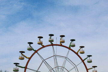 Ferris wheel with cloudy blue sky background