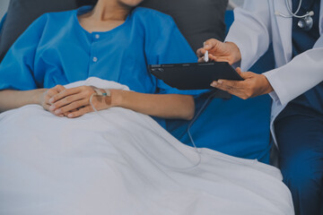 Asian Doctor make routine health check with patient in hospital ward