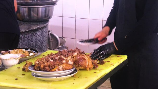 Man chops horse meat on a table and getting prepared for uzbek plov mixture