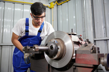 factory worker or technician working and control lathe machine in factory