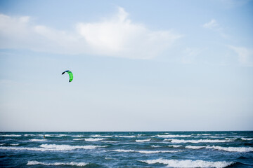 Sportsman kitesurfing on sea waves