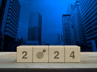 2024 start up business icon on wood block cubes on wooden table over modern office city tower and skyscraper, Happy new year 2024 success concept