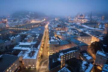 Evening winter view of old town Salzburg with river and light trails
