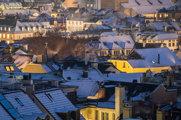 Evening winter scene with snowy roofs and city lights in Zurich