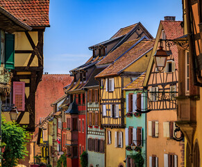 Ornate traditional half timbered houses with blooming flowers in a popular village on the Alsatian Wine Route, in Riquewihr, France