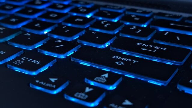 Close-up of a Gaming laptop keyboard. With an RGB backlit gaming keyboard in a dark room.