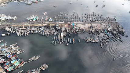 Obraz premium aerial view fishing pier. wooden boat anchored at Muncar fishing pier, Banyuwangi, Indonesia.
